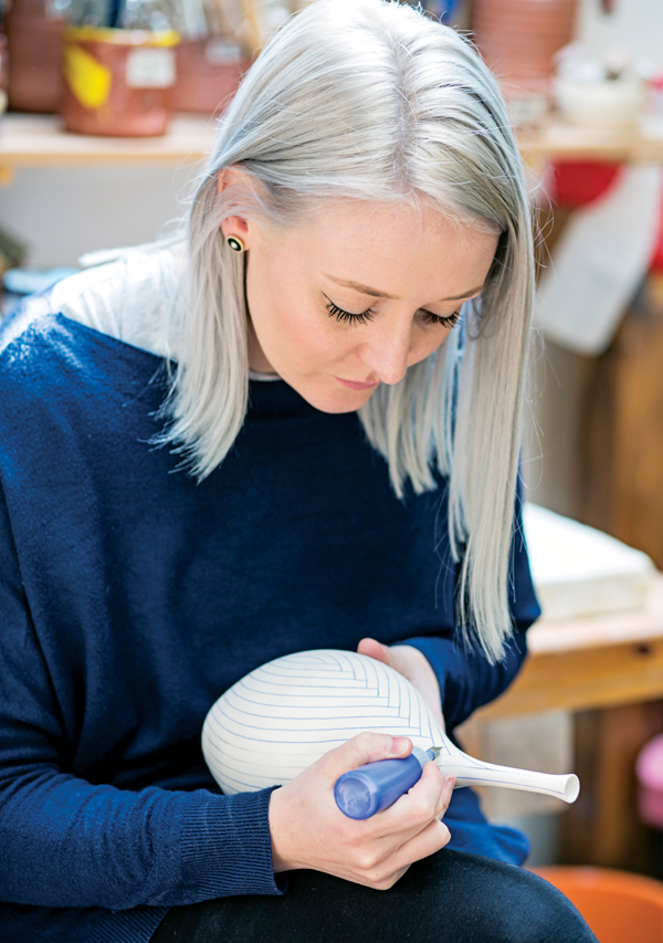 1 Rhian Malin hand painting a Layered Lines Bottle. Photo: Lucy Barriball. 