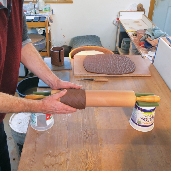 4 Using a rolling pin, form the slab into a cylinder for the body of the mug.