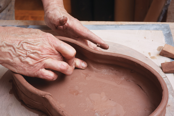 5 Smooth the interior join between the walls and the slab bottom, then flip the tray to smooth the outer seam.