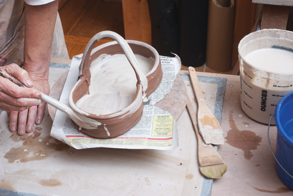 11 Coat the tray with a layer of white slip to create the ground for the surface decoration, then set it aside.