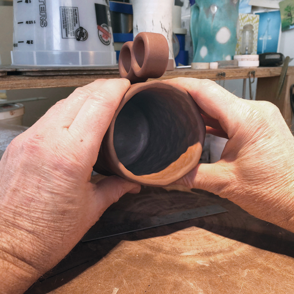 14 Squeeze the mug into an oval. It will return to cylindrical as it dries and fires.