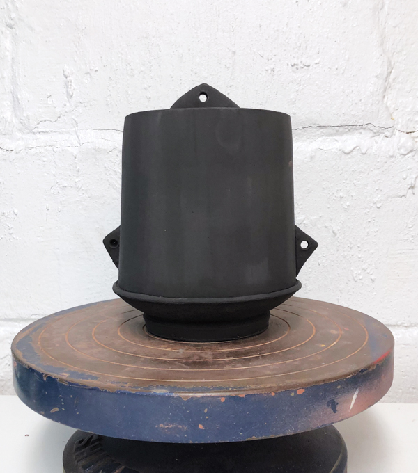 8 After the first bisque firing, cover the pot in black underglaze.