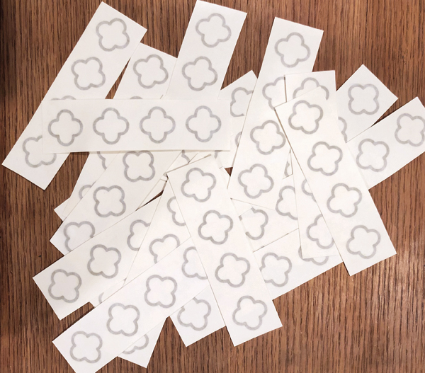 11 Prepare vinyl stencils to be applied to the pot by applying transfer tape and cutting them into strips.