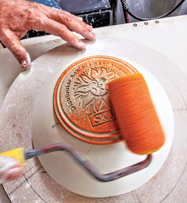 3 Roll underglaze on using a foam sponge roller after the disk has been trimmed and the cut edge is finished.