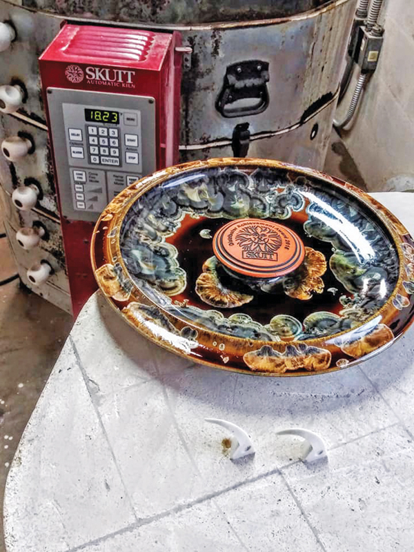 6 The glaze fuses the logo disks in place during the firing.