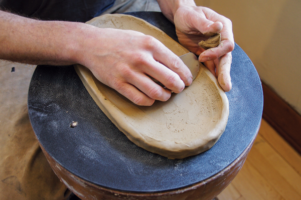 2 Use your fingers and a rib to shape and bring the sides of the form up slightly.