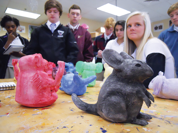 1 A class critiques the hollow-built animal sculptures from a project that challenged beginning students to communicate through gesture, expression, and color.