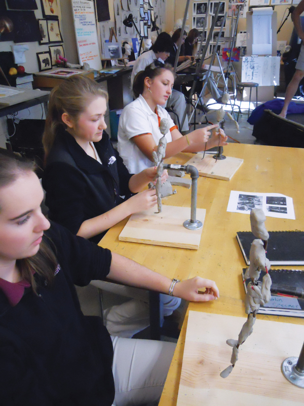 4 Students learn to sculpt figures using wire armatures during a live model session. 