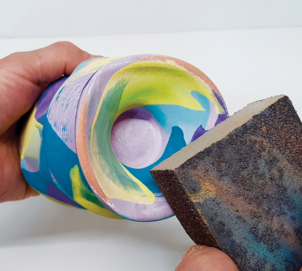 3 Use a multipurpose sanding pad to remove underglaze from the foot.
