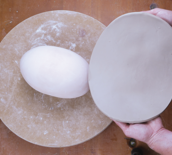 3 Place the oval slab perpendicular to the mold’s longer axis and drop it in place.