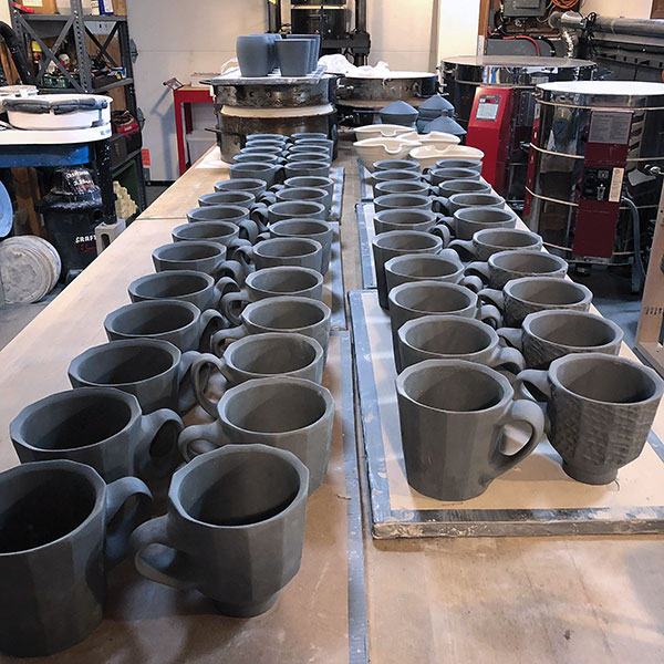 9 Pressed mugs and handled cups. These are all about to be dipped in white porcelain slip.