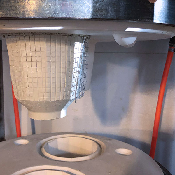 7 A freshly pressed footed cup stamped using a piece of hardware cloth to create a grid texture.