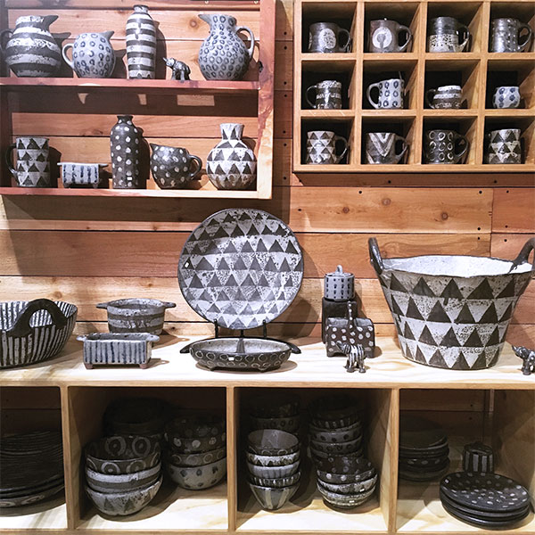 Shelves in the stand-alone gallery stocked with pots.