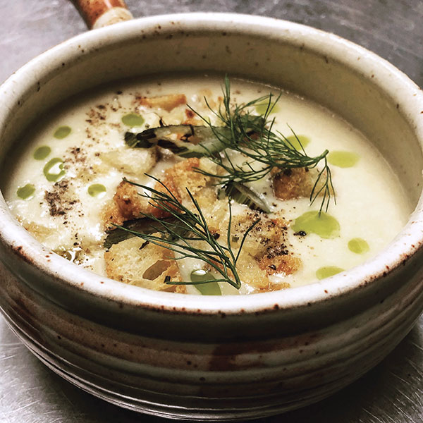 1 Leek and potato soup with duck-fat croutons, carrot-top oil, and pepper in a wheel-thrown stoneware soup crock. Photo: Jeff Taibe. 