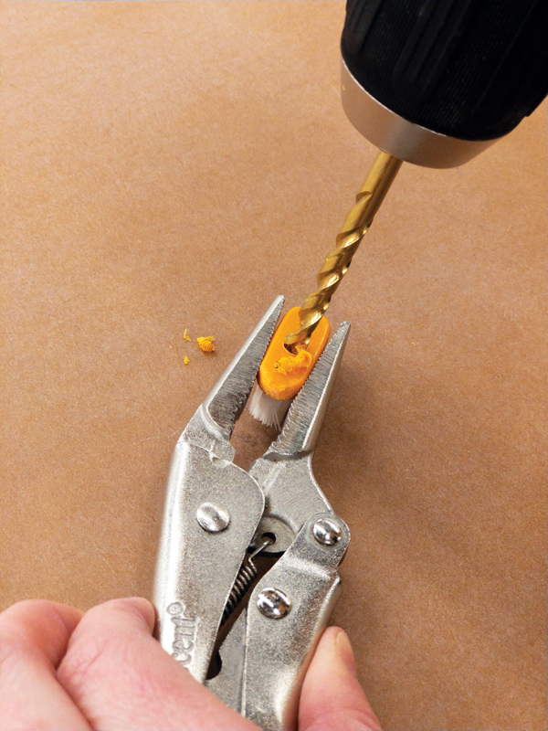 3 Hold the toothbrush head with locking pliers, then drill a shallow hole in the back of the removed toothbrush head.