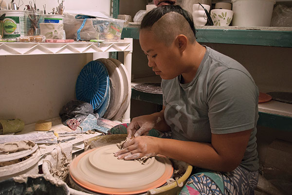 5 Ailynda Ho trimming a plate in her studio space at MCC.