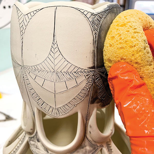 11 Sponge off the excess underglaze with a damp sponge. Be sure to rinse and wring out the sponge between cleanings. 