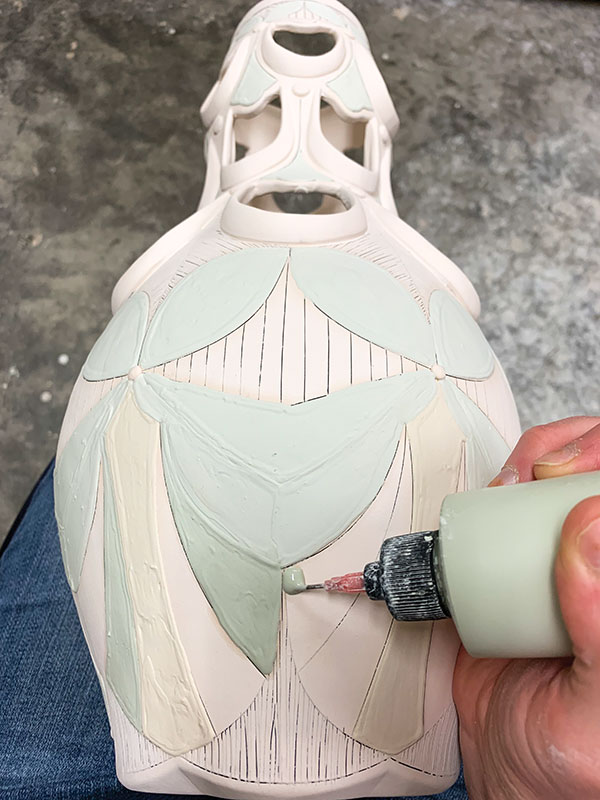 12 Apply colored glazes to individual sections of the pattern using a glaze-trailing bottle.