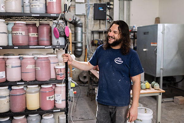 9 Jeff Perkins, Clay Studio assistant, standing next to various glaze mixtures made by Heath staff.
