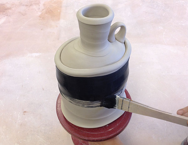 1 Apply two thin coats of black underglaze with a soft-bristled mop or hake brush.