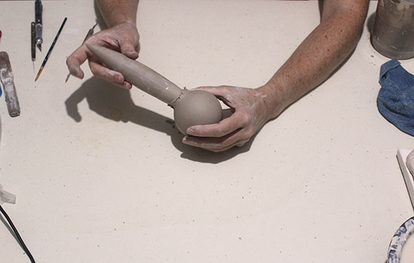 4 Joining together separate cast clay components, like the sphere and the seed-pod shape to form the inner part of the work.