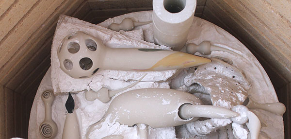 10 After the second high firing, the balls and the sharp ending of the chains are locked in place. Note the alumina used to keep the components from sticking together.