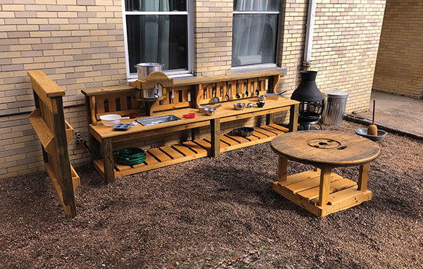 3 Chattanooga Mud Kitchen (interactive outdoor kitchen, shelves, table), 15 ft. (4.6 m) in length (includes entire play area), wood, metal, Northside Learning Center, Chattanooga, Tennessee. Designed by Vicky Flessner of PLAYceMaker with help from McCosh Landscaping and Supply, 2019.