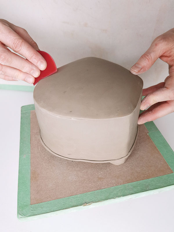 6 Once it’s firm enough to hold its shape, attach the slumped slab top to the teapot body. Compress it with a soft red rib.