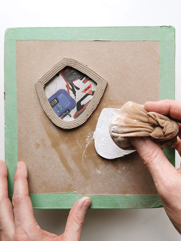 8 Remove the lid section, then score and slip the collar. Dust the newspaper side of the lid with cornstarch and replace it.