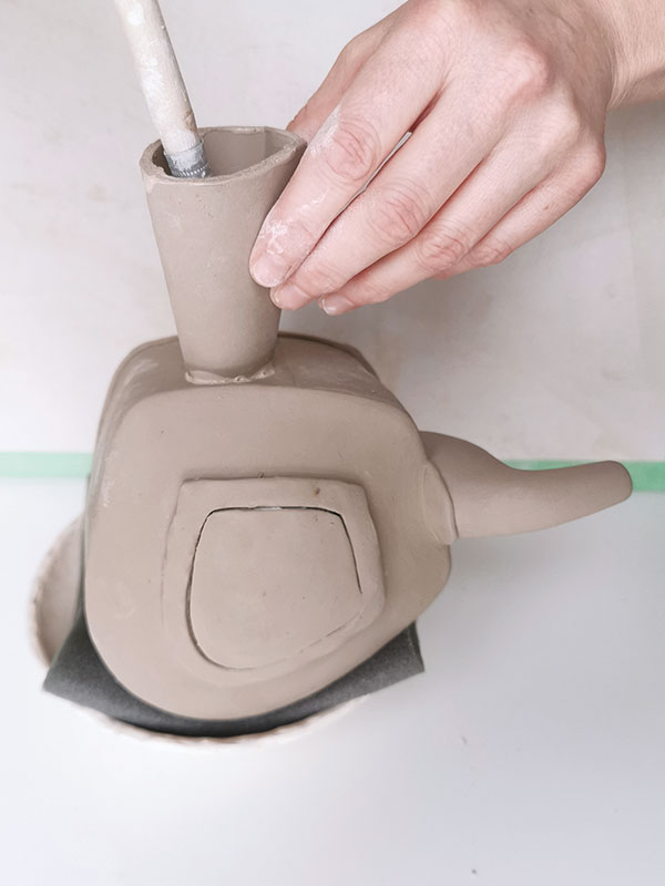 16 Assemble the teapot in a shallow, foam-lined bowl. Add the handle, then clean up the interior seam using a dry brush.
