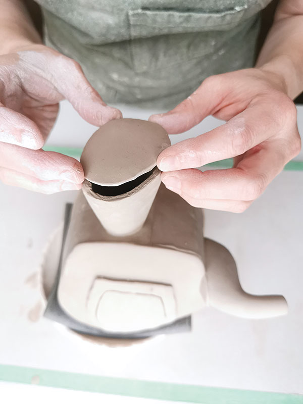 17 Add a cut, trimmed, and shaped soft slab to enclose the end of the handle. Poke a small hole to allow air to escape.