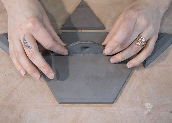 5 Score and add slip to both parts, then attach the trapezoid-shaped shelf to the large hexagonal base.