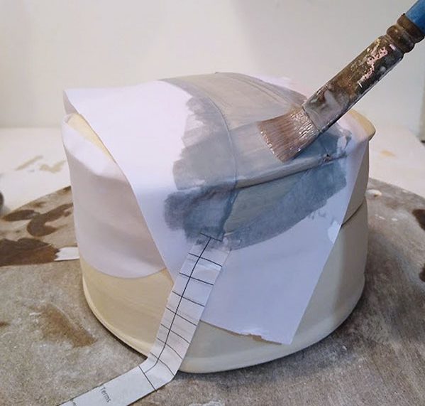 1 Apply paper resist and brush on underglaze for a decorative base layer.
