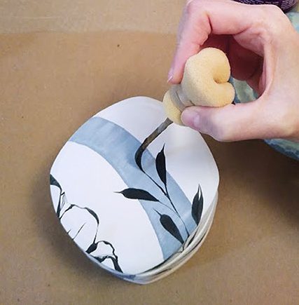 3 Apply brushwork with black underglaze using a pinstriping brush.