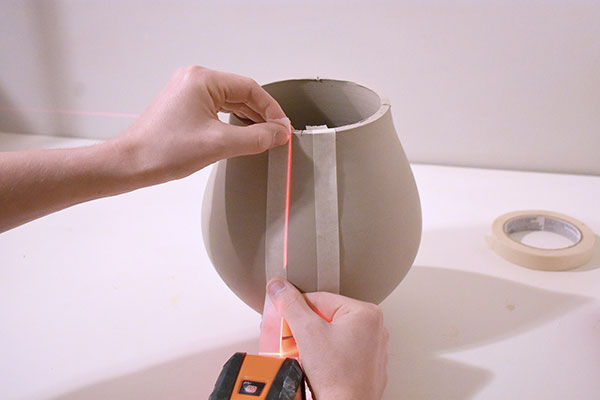 3 Use a laser level to place tape the same distance on both sides of each mark.