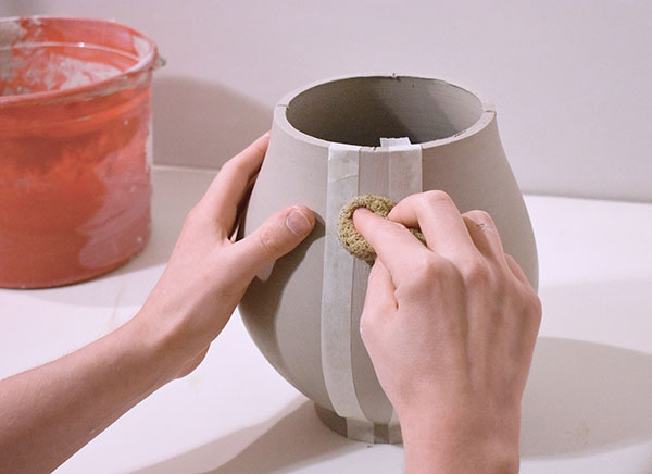 4 Use a sponge, clean water, and even pressure to etch the clay between the tape.