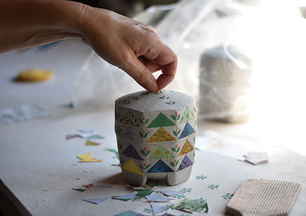 13 Wet the back of each piece of paper and lightly press it onto the surface of the urn. 