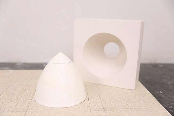1 A lathed plaster prototype and one of several recast plaster molds before cutting.