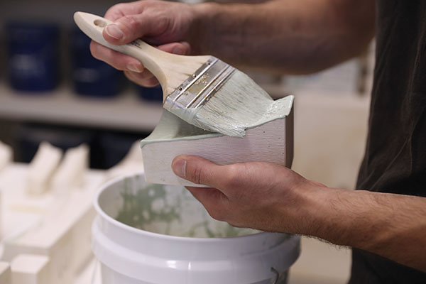 7 Brush layers of colored slip onto the faces of the mold sections to create both texture and appropriate panel thickness.