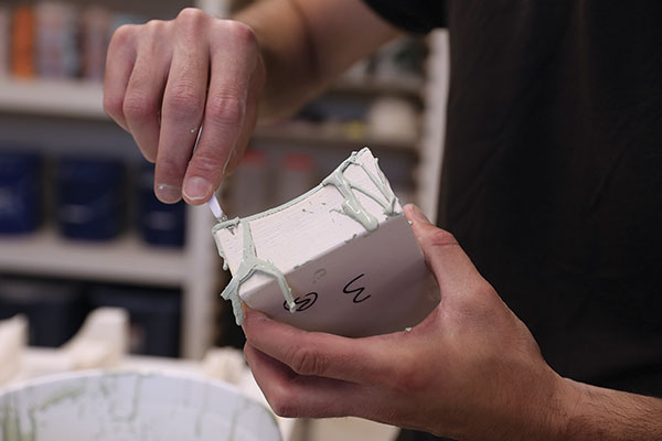 8 Use an X-Acto knife to carefully trim the excess slip off the mold sections after painting.