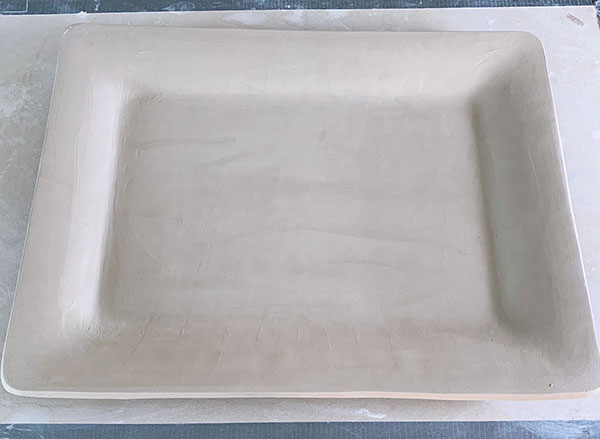 1 Start with a leather-hard piece made from very smooth clay. Then apply a layer of black underglaze over the surface.