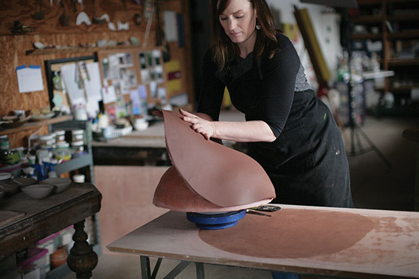 2 Cut a rough shape to fit the bisque form, then drape the slab over the mold. 