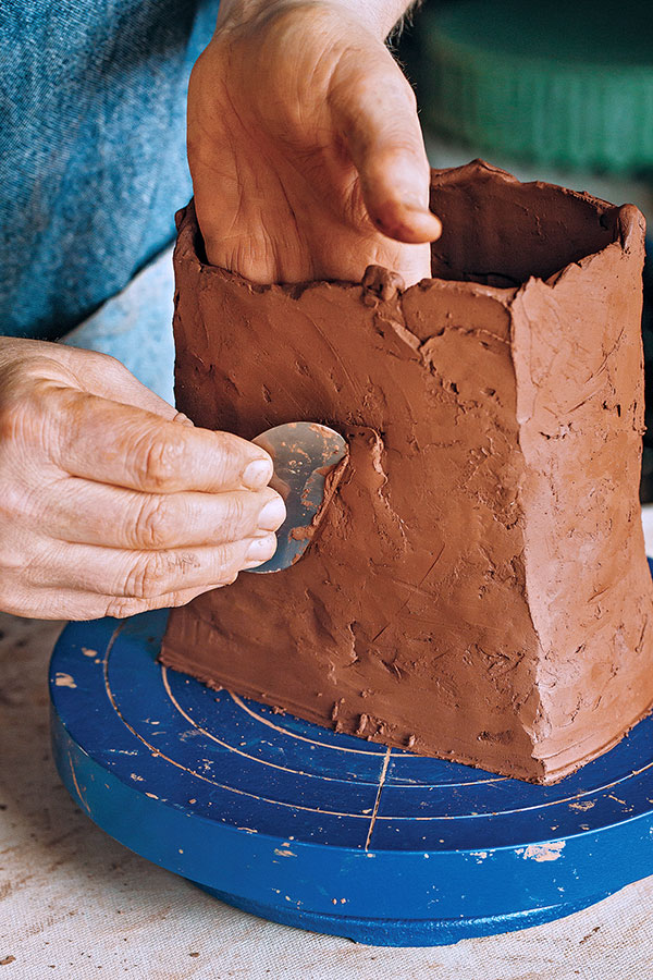 4 Compress the patch with a rib for a good join, then blend in the new clay to match the surface around the existing clay.