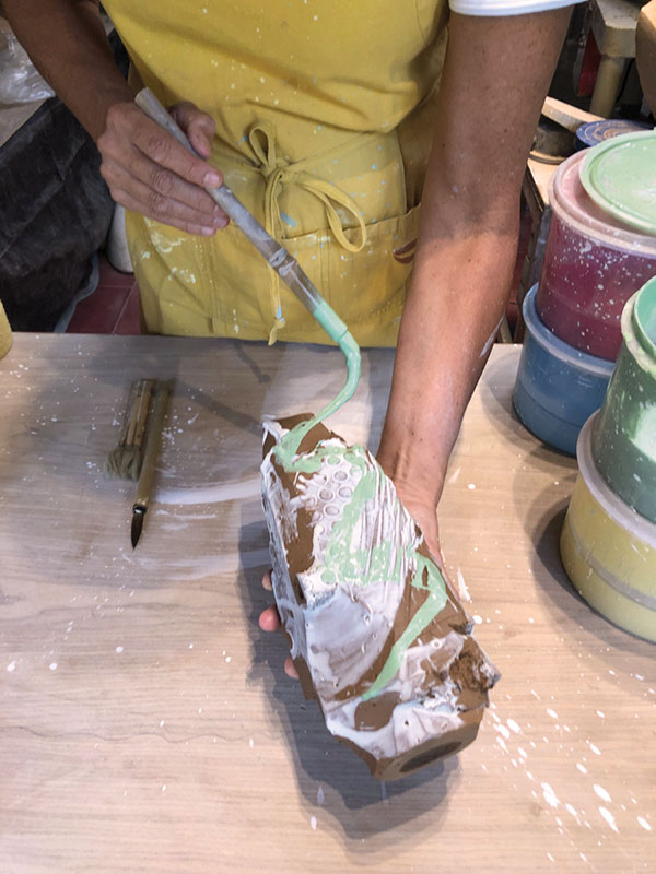 14 Apply a second color of slip with a thinner brush in fluid, painterly motions.