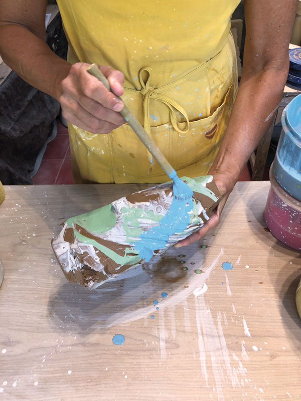 15 Apply additional layers of colored slip to build up depth.