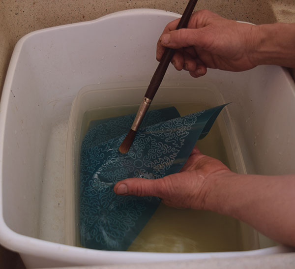 2 Soak the stencil in water for 20 minutes, then scrub it to remove the emulsion.