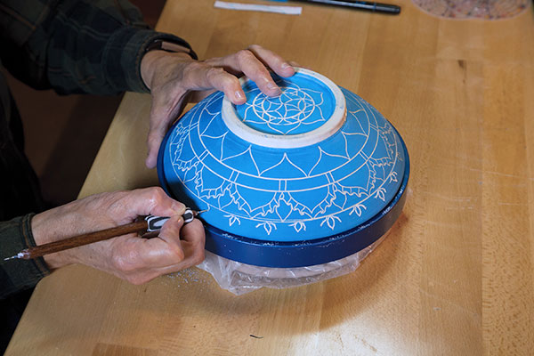 4 Lay out the main mandala structure with a carving tool/stylus, working from the center and finishing at the rim.