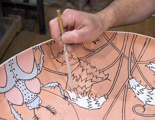 5 Apply glaze with a brush by jiggling the glaze onto the surface. The fluid glaze is contained by the wax lines.