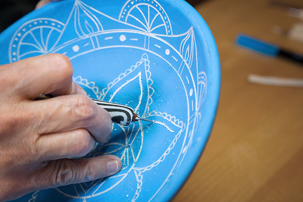 5 Fill the main mandala shapes with detail and pattern, working from the rim and moving inward.