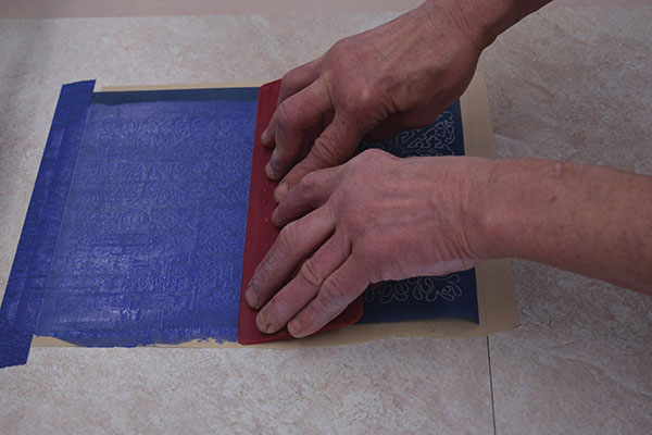6 With firm, even pressure, use a squeegee to drag the line of thickened underglaze down the stencil.